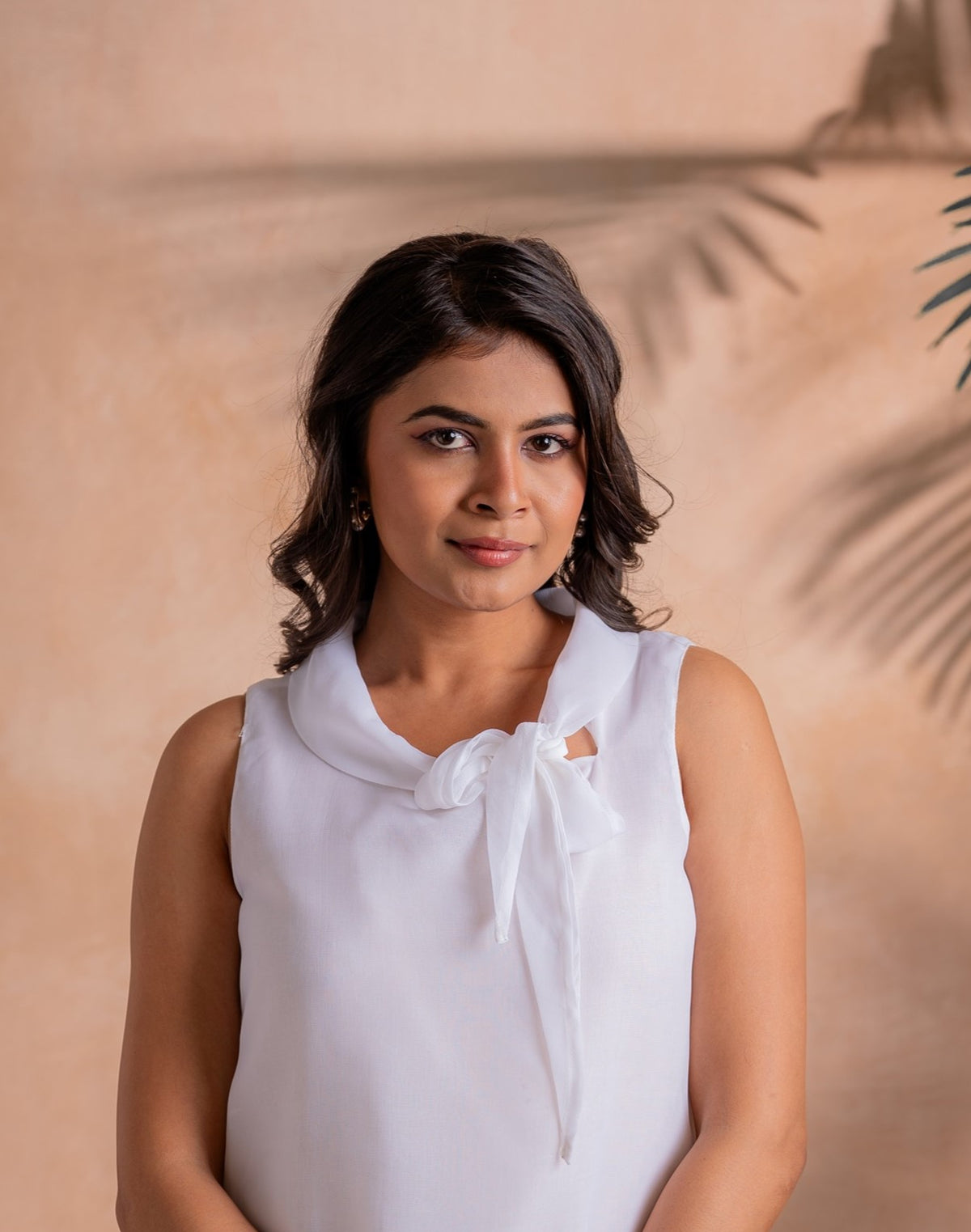 Lamora Elegant White Sleeveless Bow-Neck Layered Hem Top